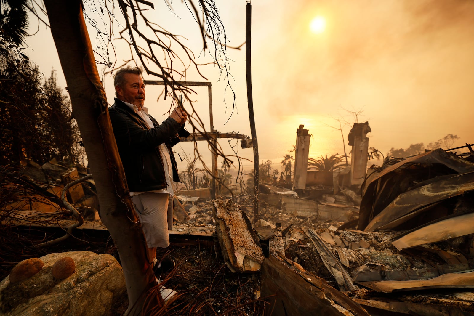 Kelly Kline looks out at his home damaged by the Palisades Fire, Wednesday, Jan. 8, 2025, in Malibu, Calif. (AP Photo/Etienne Laurent)