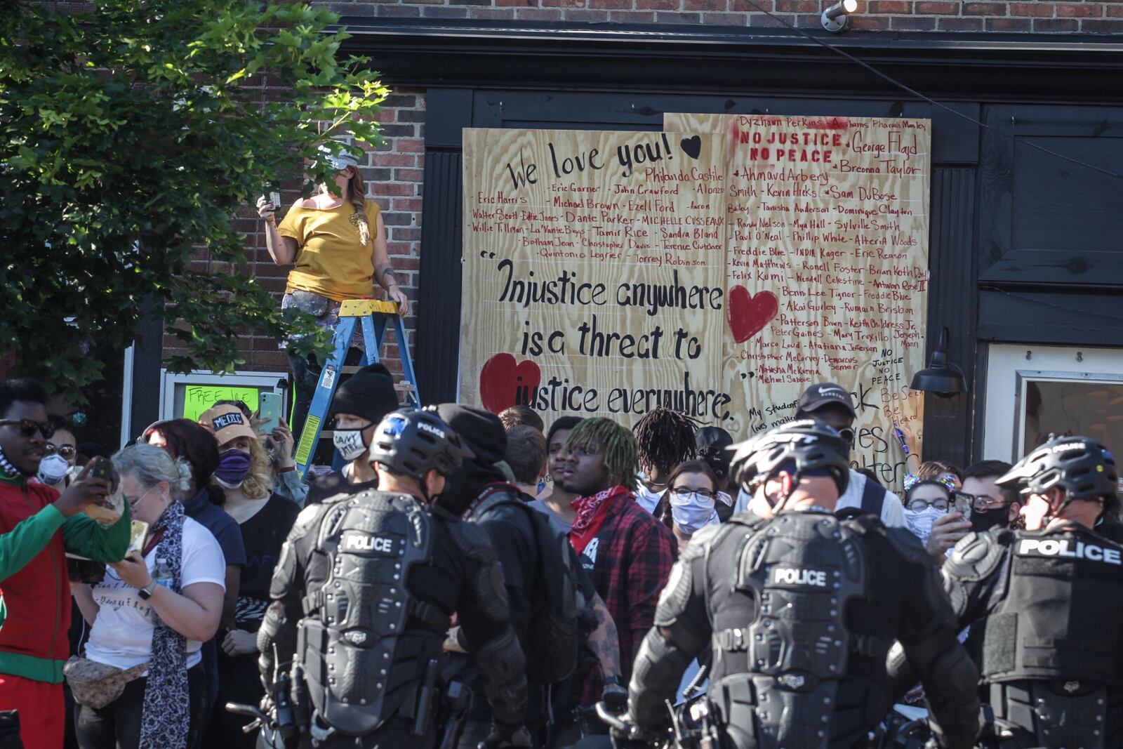 A Dayton business with a boarded up storefront window bore inspiring messages of love and peace Sunday, May 31, 2020, after it was damaged during a Saturday protest that turned into a clash with police in downtown Dayton. JIM NOELKER / STAFF