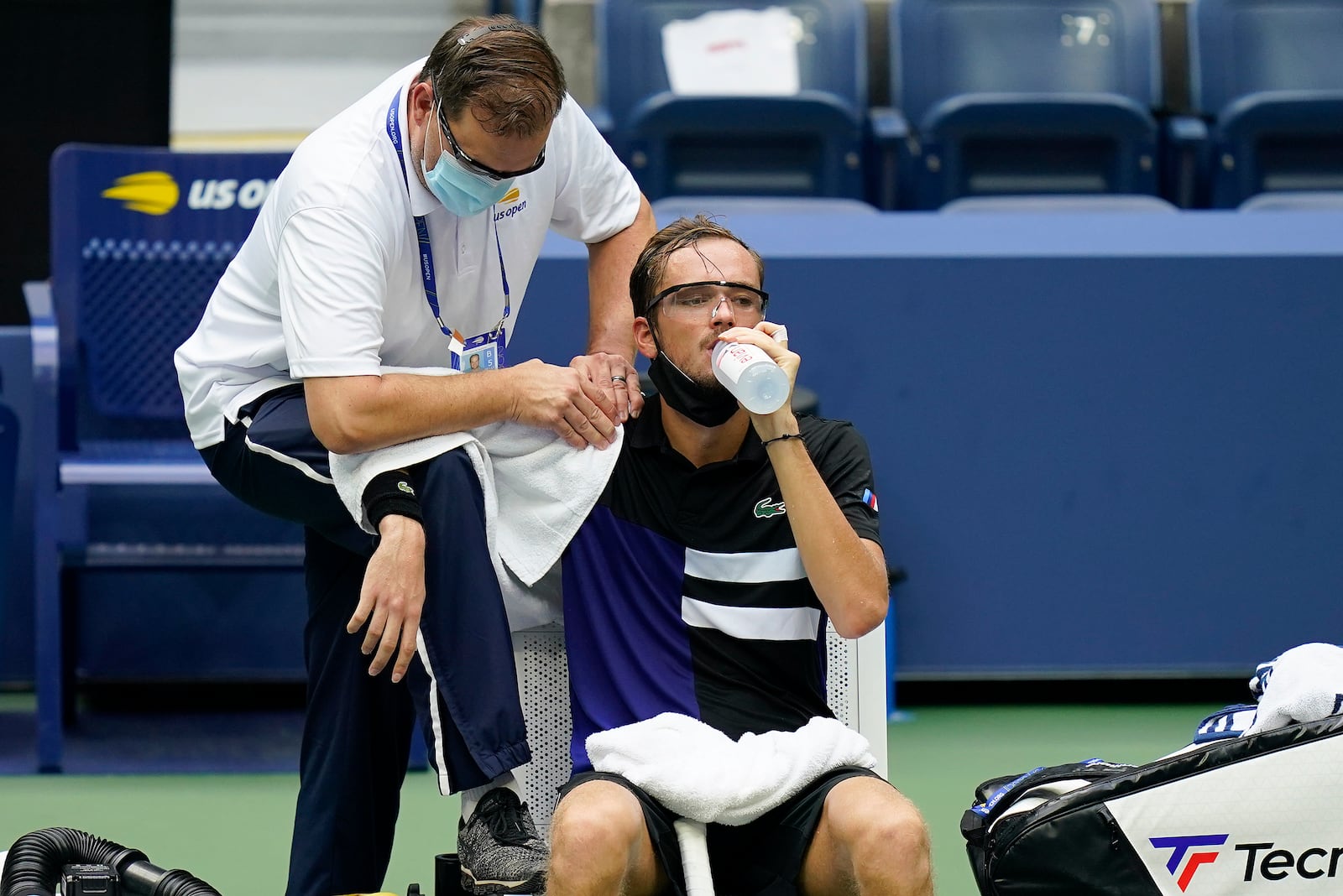 A trainer works on the shoulder of Daniil Medvedev, of Russia, during the quarterfinals of the US Open tennis championships against Andrey Rublev, of Russia, Wednesday, Sept. 9, 2020, in New York. (AP Photo/Seth Wenig)