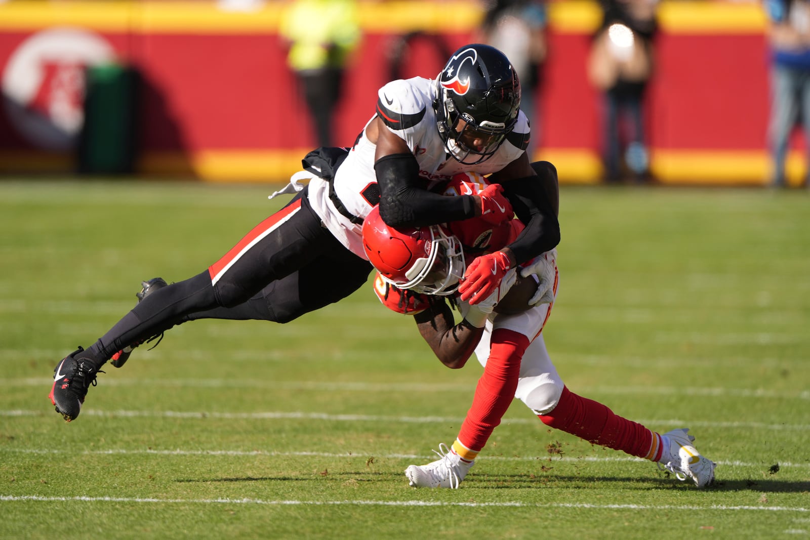 Kansas City Chiefs wide receiver Hollywood Brown is tackled by Houston Texans safety Eric Murray, left, during the first half of an NFL football game Saturday, Dec. 21, 2024, in Kansas City, Mo. (AP Photo/Charlie Riedel)