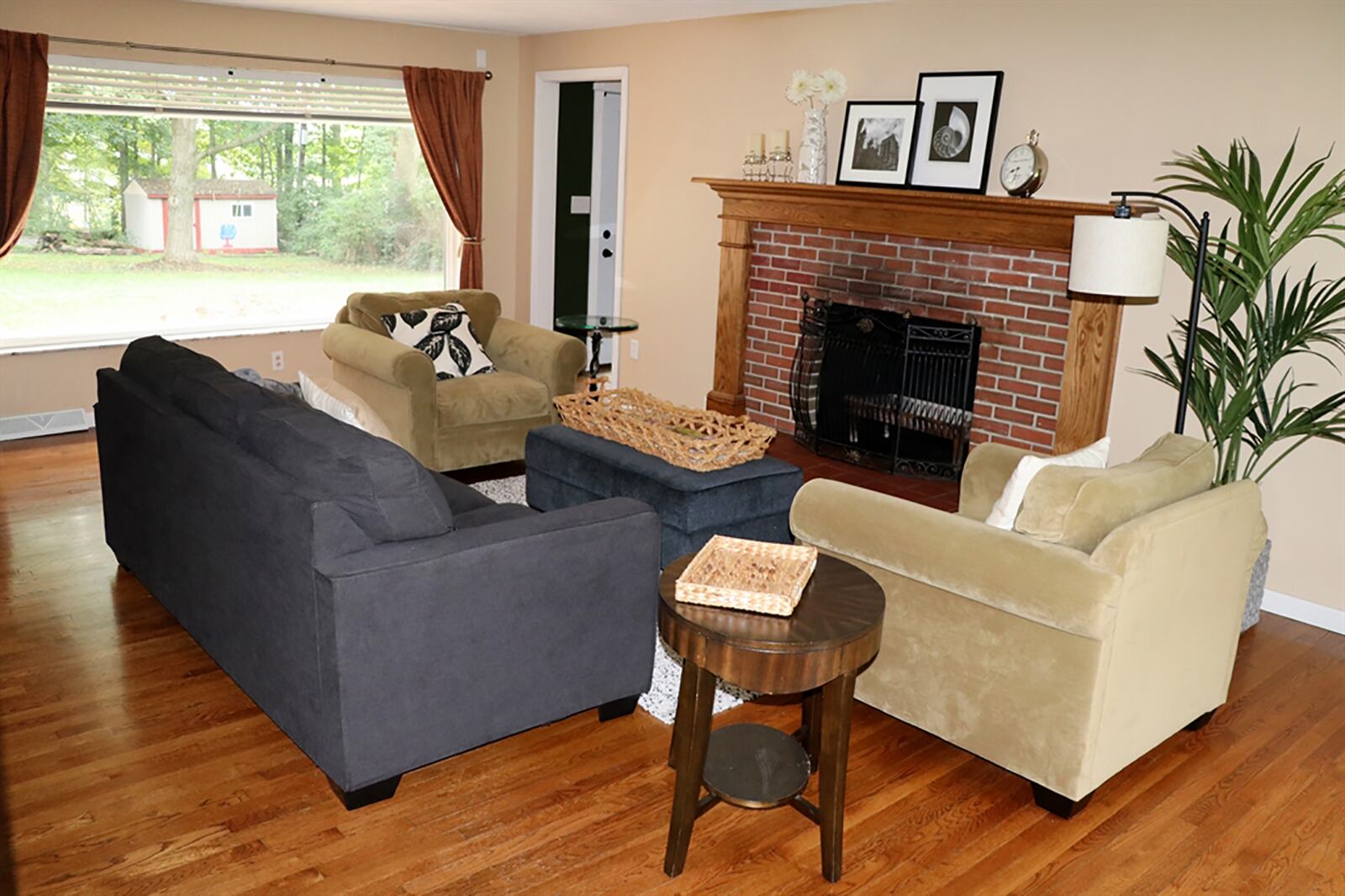 Two picture windows fill the living room with natural light and provide panoramic views of the front and back yards. A brick, wood-burning fireplace has a raised terra-cotta tile hearth and a fluted wood mantel surround. CONTRIBUTED PHOTO BY KATHY TYLER