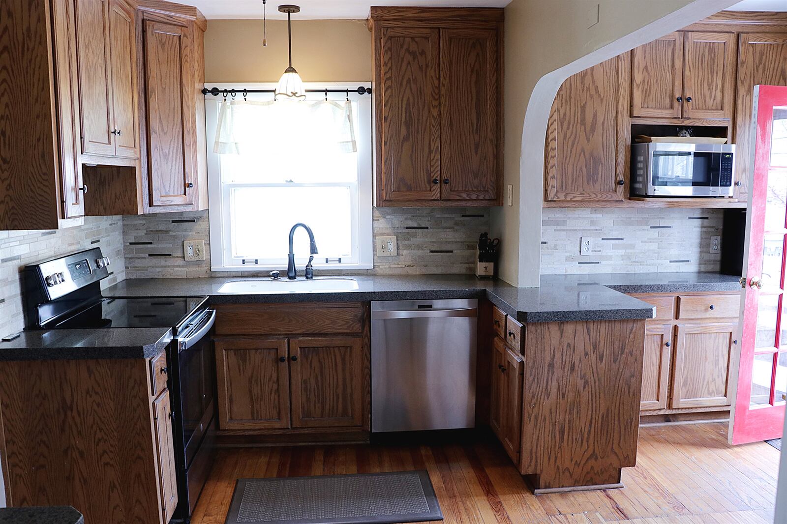 The floor plan circles around from the living room and dining room into the kitchen and breakfast room. The kitchen was redesigned with 42-inch cherry cabinetry that surround the appliances. A window is above the sink. CONTRIBUTED PHOTO BY KATHY TYLER