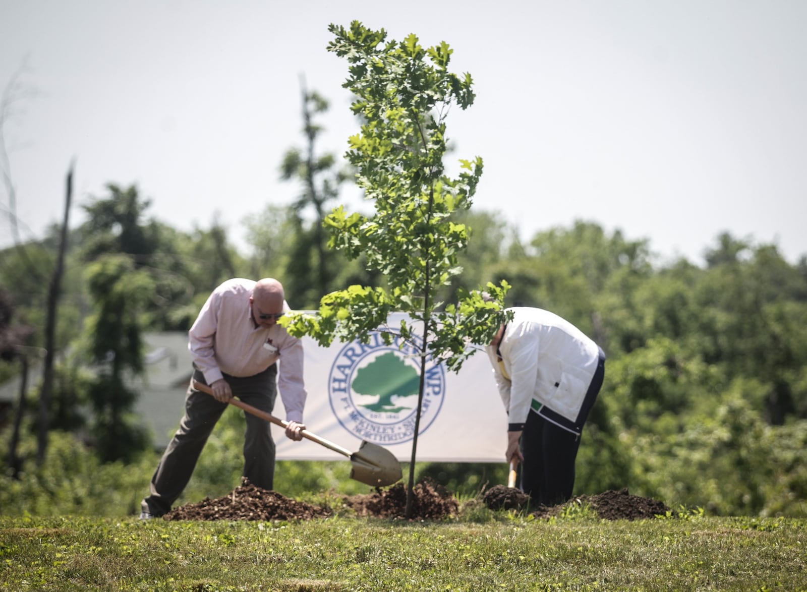 Woody Stroud, left and Harrison Twp. Trustee, Georgeann Godsey plant a tree at Sinclair Park Friday June4, 2021. The township held a tree planting kickoff at Sinclair Park to begin restoring the tree canopy lost to the Memorial Day tornados in 2019. JIM NOELKER/STAFF