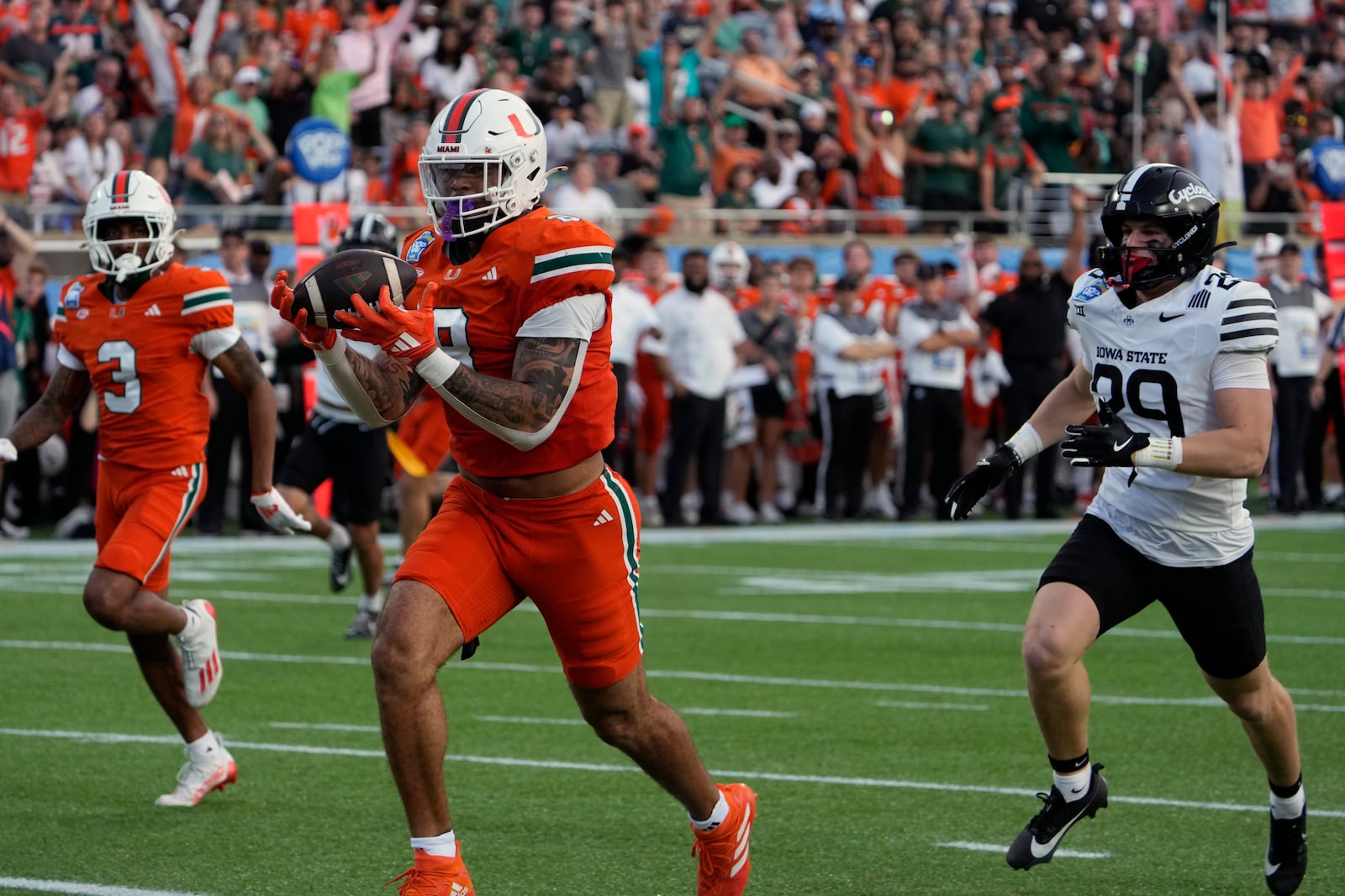 Miami tight end Elijah Arroyo catches a 33-yard touchdown pass in front of Iowa State defensive back Drew Surges (29) during the first half of the Pop Tarts Bowl NCAA college football game, Saturday, Dec. 28, 2024, in Orlando, Fla. (AP Photo/John Raoux)