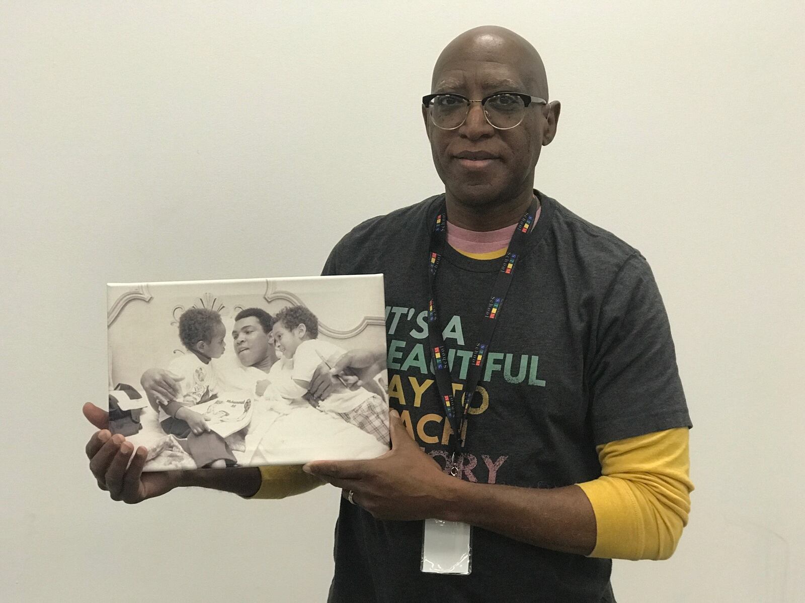 Michael Carter, Chief Diversity Officer at Sinclair Community College and former Springfield South and Trotwood Madison basketball coach, holds a photo of two year old Dave Chappelle and his three-year-old brother Sedar visiting Muhammad Ali before his 1975 fight with Jimmy Young. (Photo courtesy of Michael Carter/Sinclar CC exhibit)