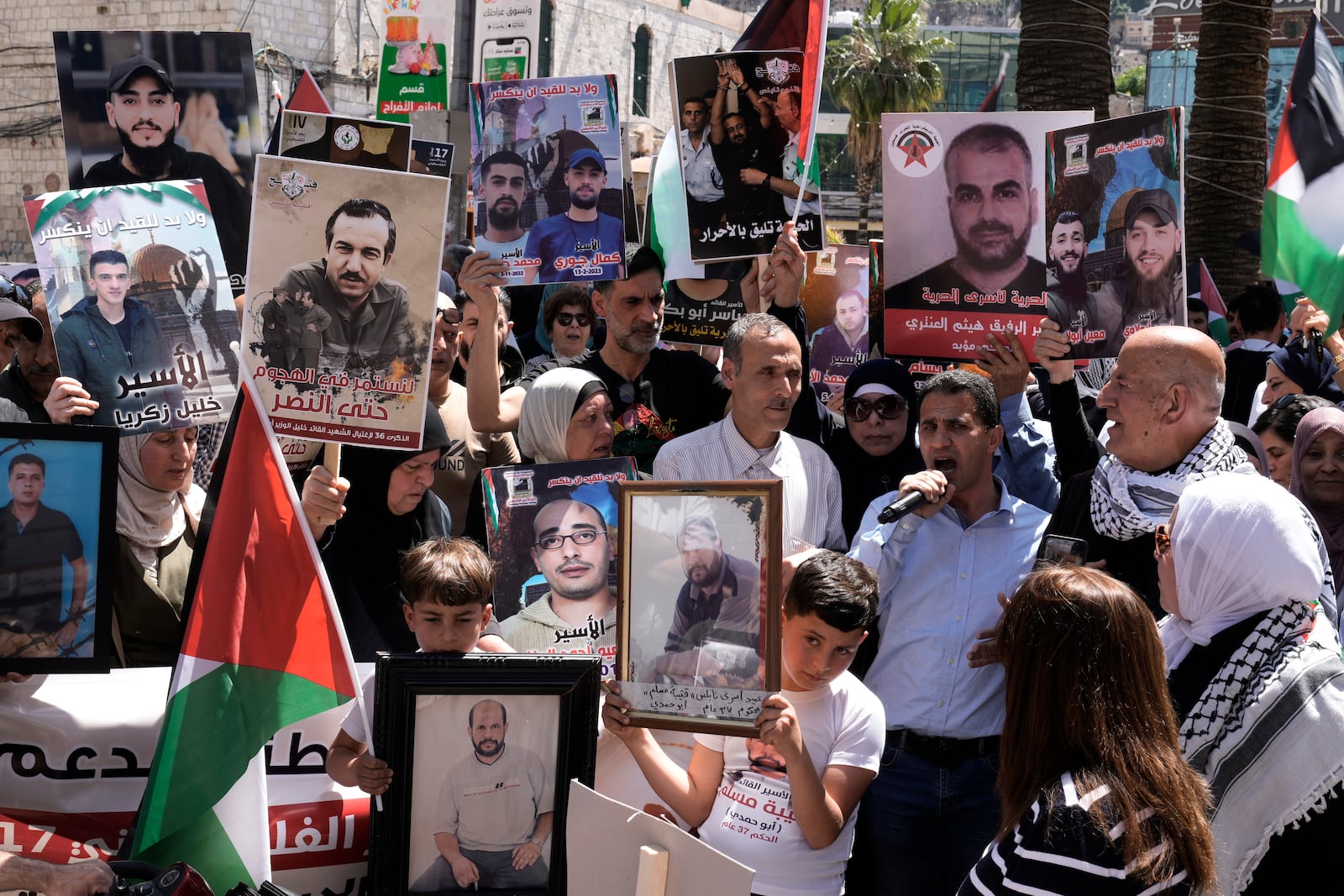 FILE - Palestinians hold photographs of prisoners jailed in Israel during a rally marking the annual prisoners' day in the West Bank city of Nablus, on April 17, 2024. (AP Photo/Majdi Mohammed, File)