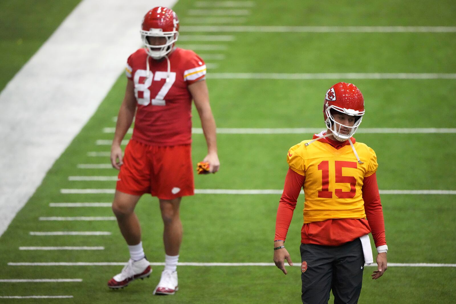 Kansas City Chiefs quarterback Patrick Mahomes (15) and tight end Travis Kelce (87) stretch during the team's NFL football practice Thursday, Jan. 23, 2025, in Kansas City, Mo. (AP Photo/Charlie Riedel)