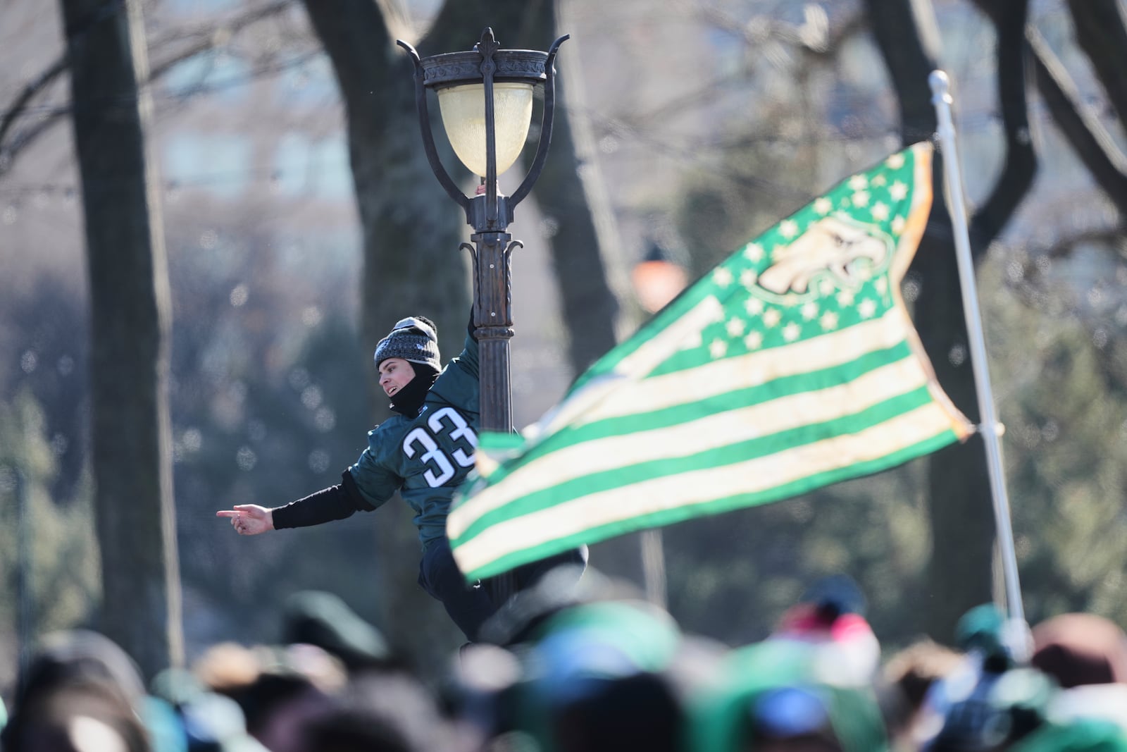 A fan hangs from a lamp post during the Philadelphia Eagles' NFL football Super Bowl 59 parade and celebration, Friday, Feb. 14, 2025, in Philadelphia. (AP Photo/Matt Rourke)