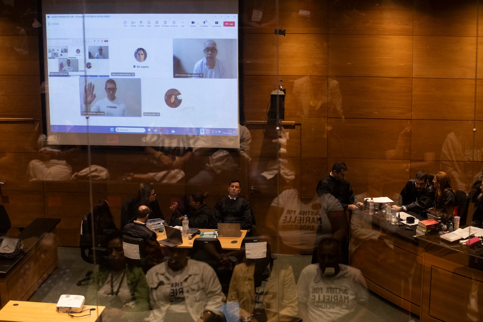 Former military police officers, shown on screen, from left, Ronnie Lessa and Elcio Queiroz attend via video conference their trial where they are accused of murdering city councilwoman Marielle Franco and driver Anderson Gomes, at the Court of Justice in Rio de Janeiro, Wednesday, Oct. 30, 2024. (AP Photo/Bruna Prado)