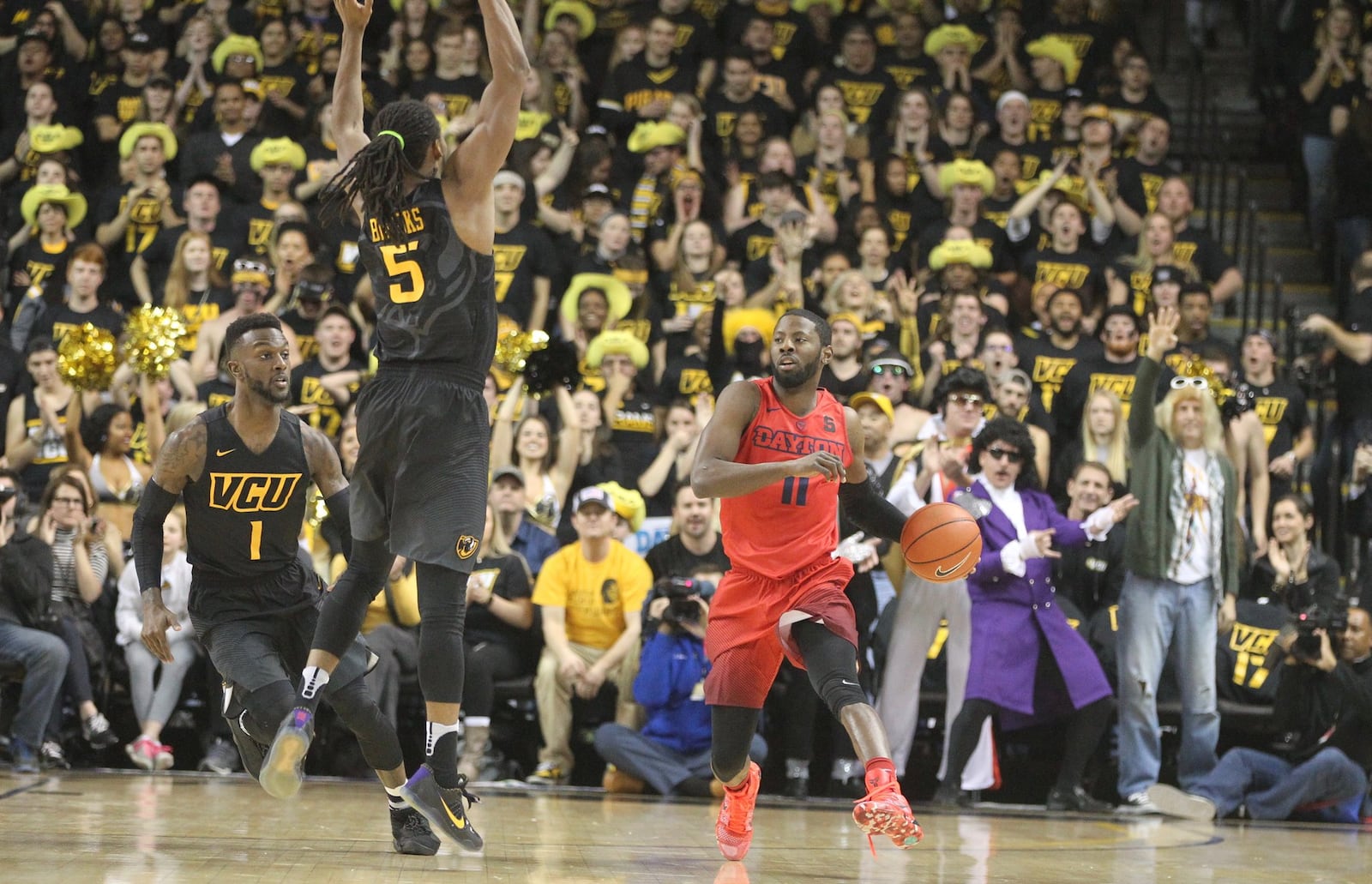 Dayton’s Scoochie Smith brings the ball up the court against Virginia Commonwealth’s JeQuan Lewis, left, and Jordan Burgess, center, on Friday, Jan. 27, 2017, at UD Arena. David Jablonski/Staff