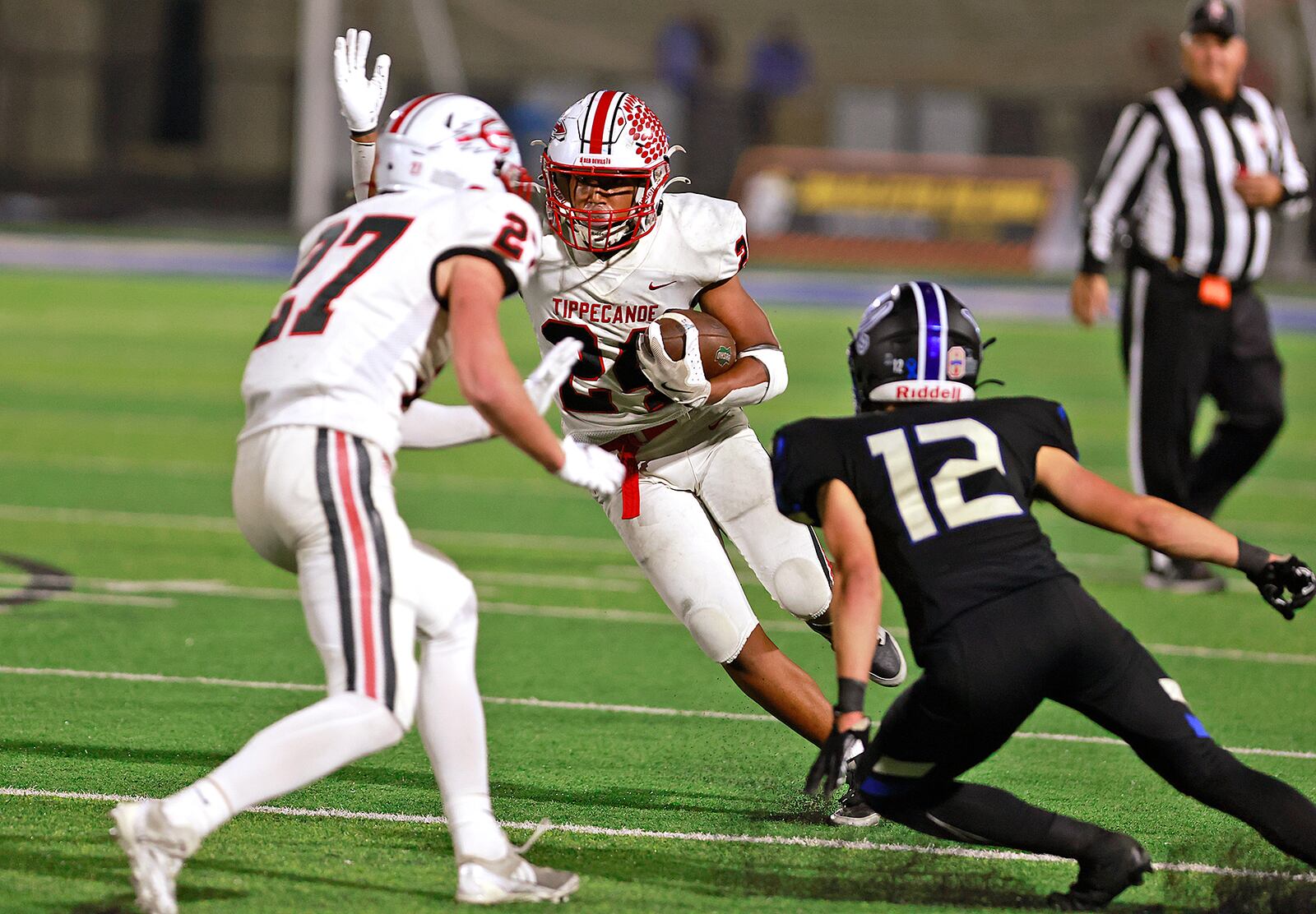 Tipp's Xavier Melton carries the ball against Xenia Friday night. BILL LACKEY/STAFF