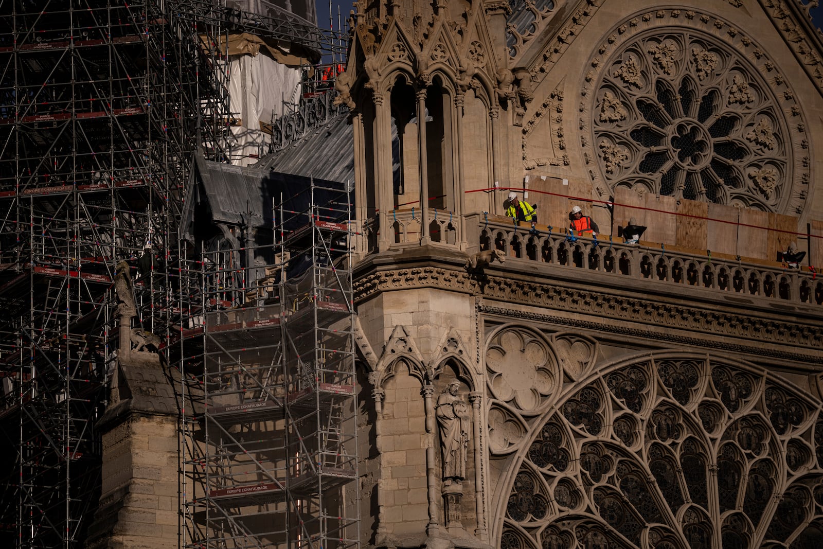 Workers stand on Notre-Dame cathedral in Paris, Wednesday, Nov. 20, 2024. (AP Photo/Louise Delmotte)