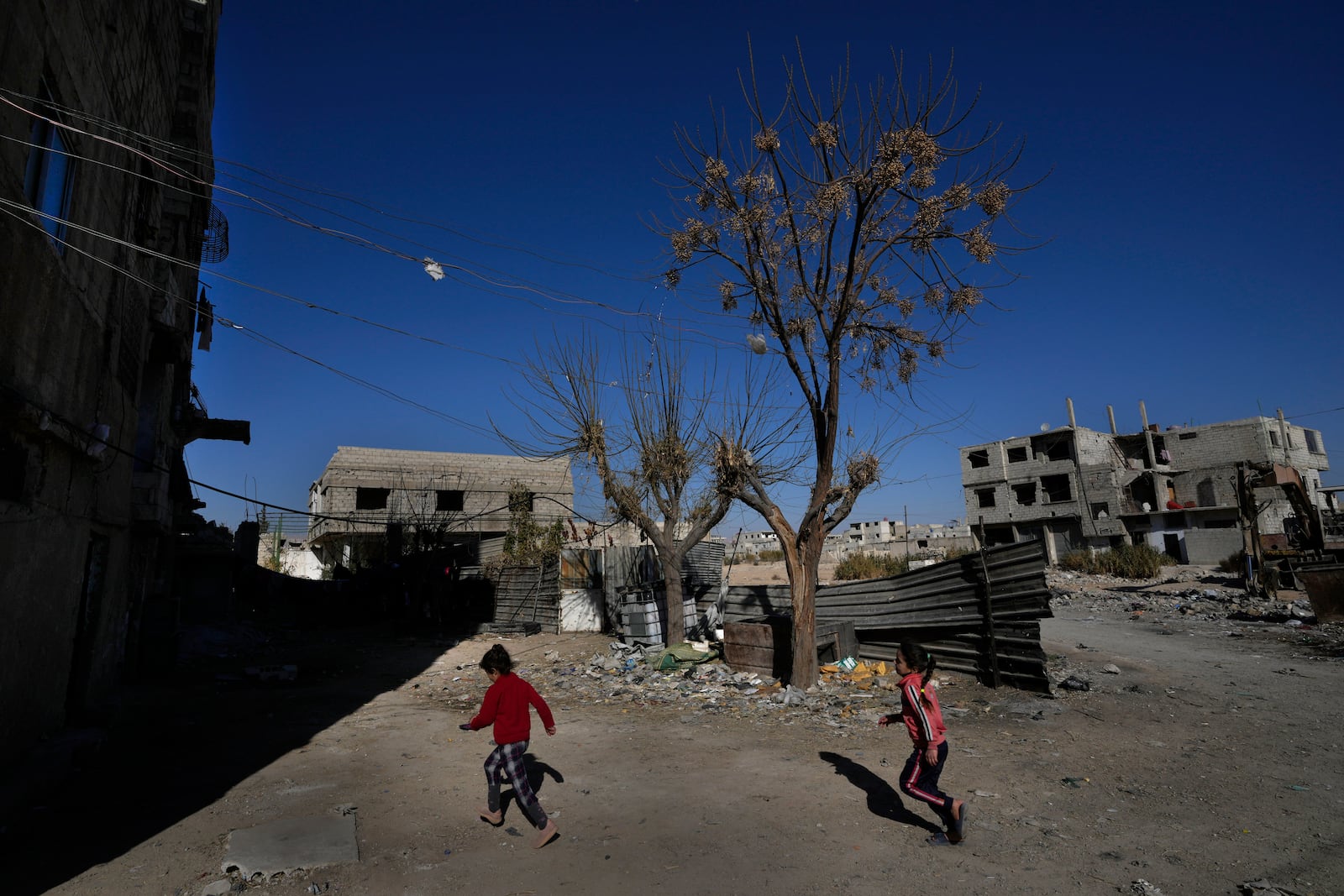 Syrian girls plays at an alley that was hit by the sarin struck during a 2013 chemical weapons attack that was blamed on then President Bashar Assad's forces, in Zamalka neighbourhood, on the outskirts of Damascus, Syria, Wednesday, Dec. 25, 2024. (AP Photo/Hussein Malla)