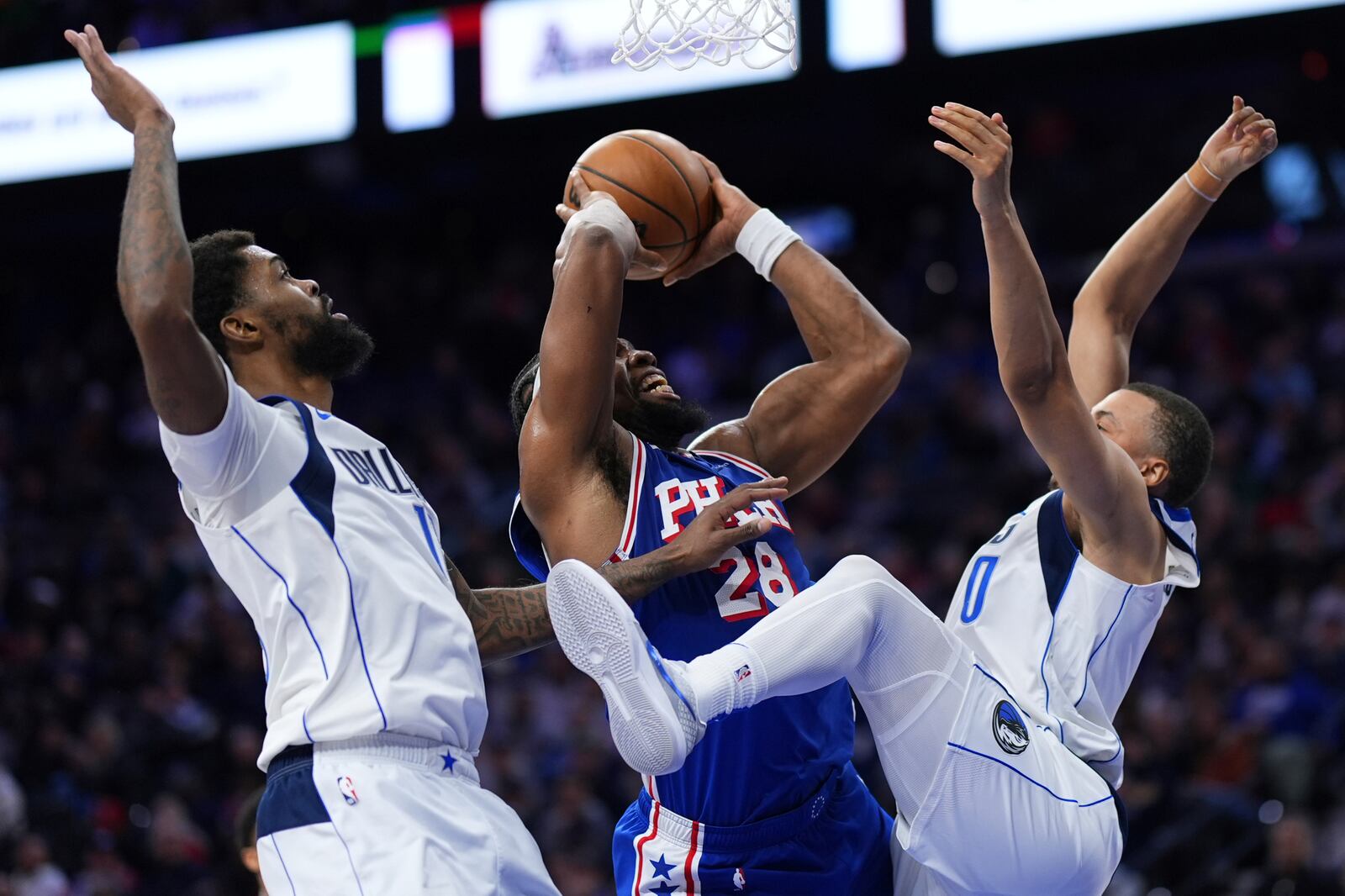 Philadelphia 76ers' Guerschon Yabusele, center, goes up for a shot against Dallas Mavericks' Dante Exum, right, and Naji Marshall during the second half of an NBA basketball game, Tuesday, Feb. 4, 2025, in Philadelphia. (AP Photo/Matt Slocum)