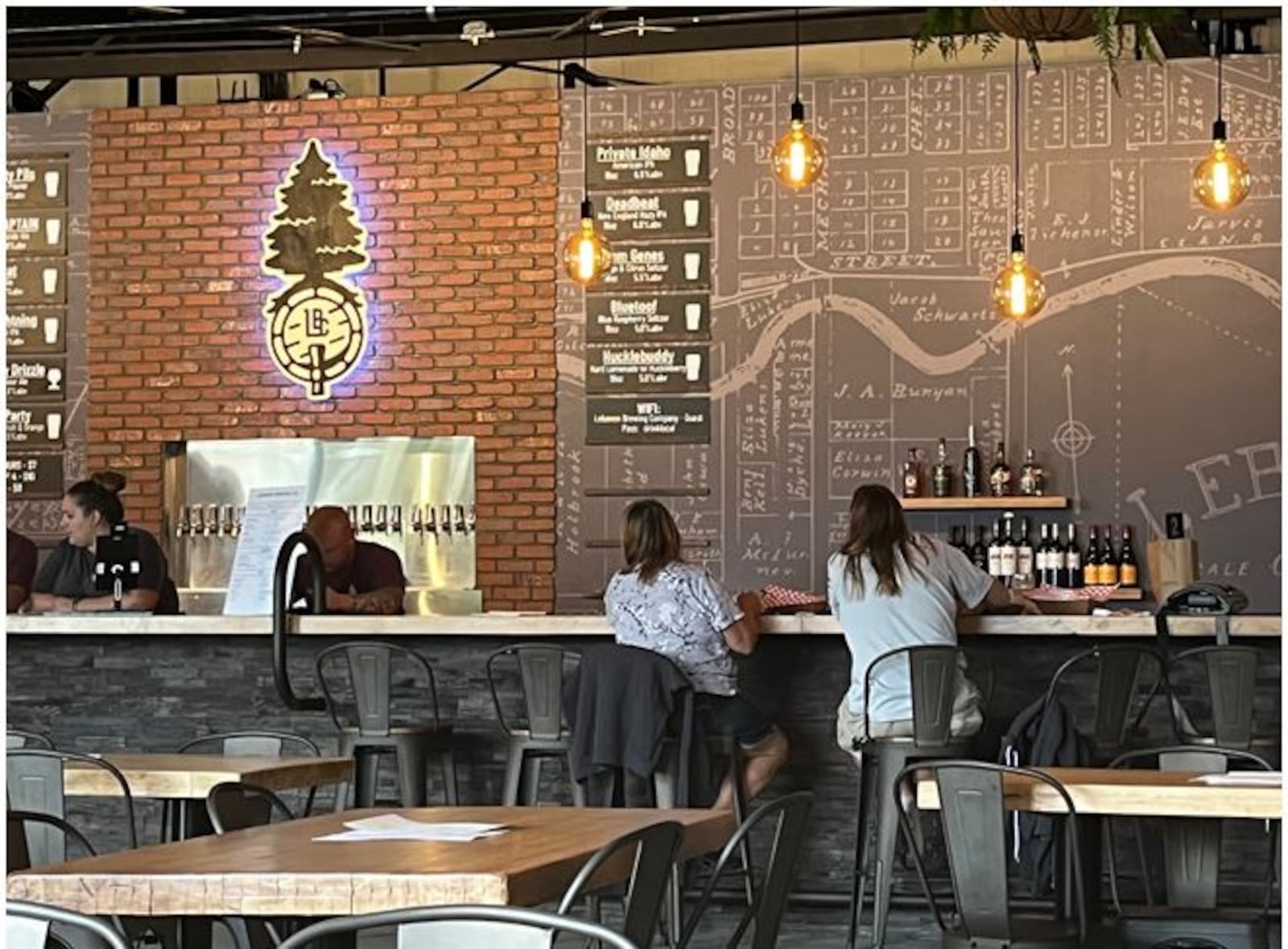 Patrons enjoy beverages at the 40-foot bar at the Lebanon Brewing Company during a pre-opening event earlier this week. The new brewery opens to the public today.  ED RICHTER/STAFF