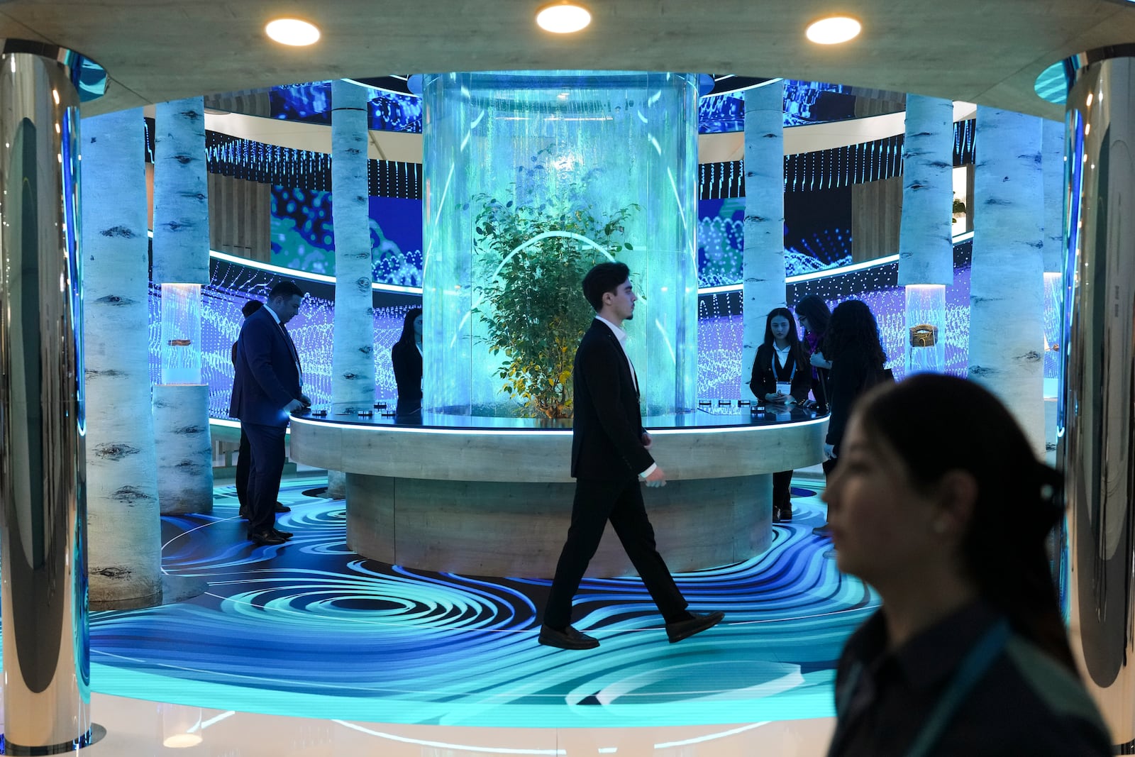 People walk through an exhibit in the Green Zone at the COP29 U.N. Climate Summit, Monday, Nov. 11, 2024, in Baku, Azerbaijan. (AP Photo/Sergei Grits)