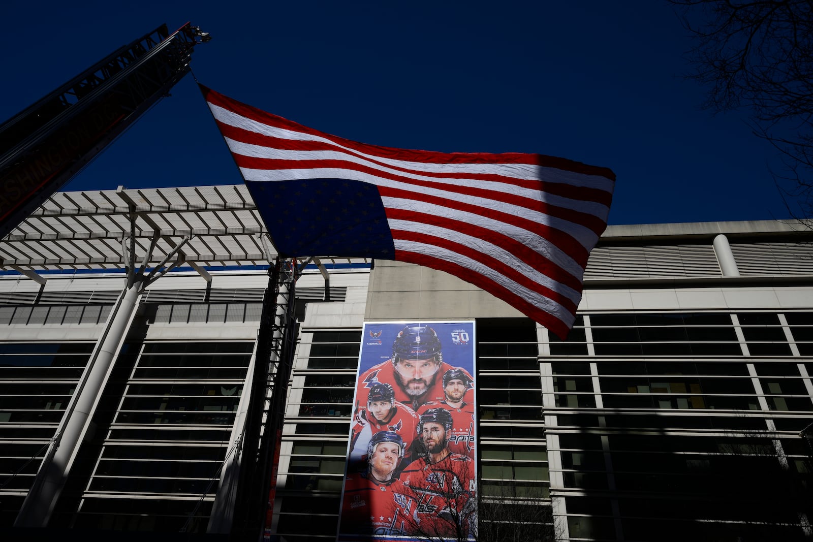 An American flag is flown outside of Capital One Arena before the Legacy on Ice event, a figure skating tribute to support the families and loved ones affected by the tragic January 29th aviation incident, Sunday, March 2, 2025, in Washington. (AP Photo/Nick Wass)