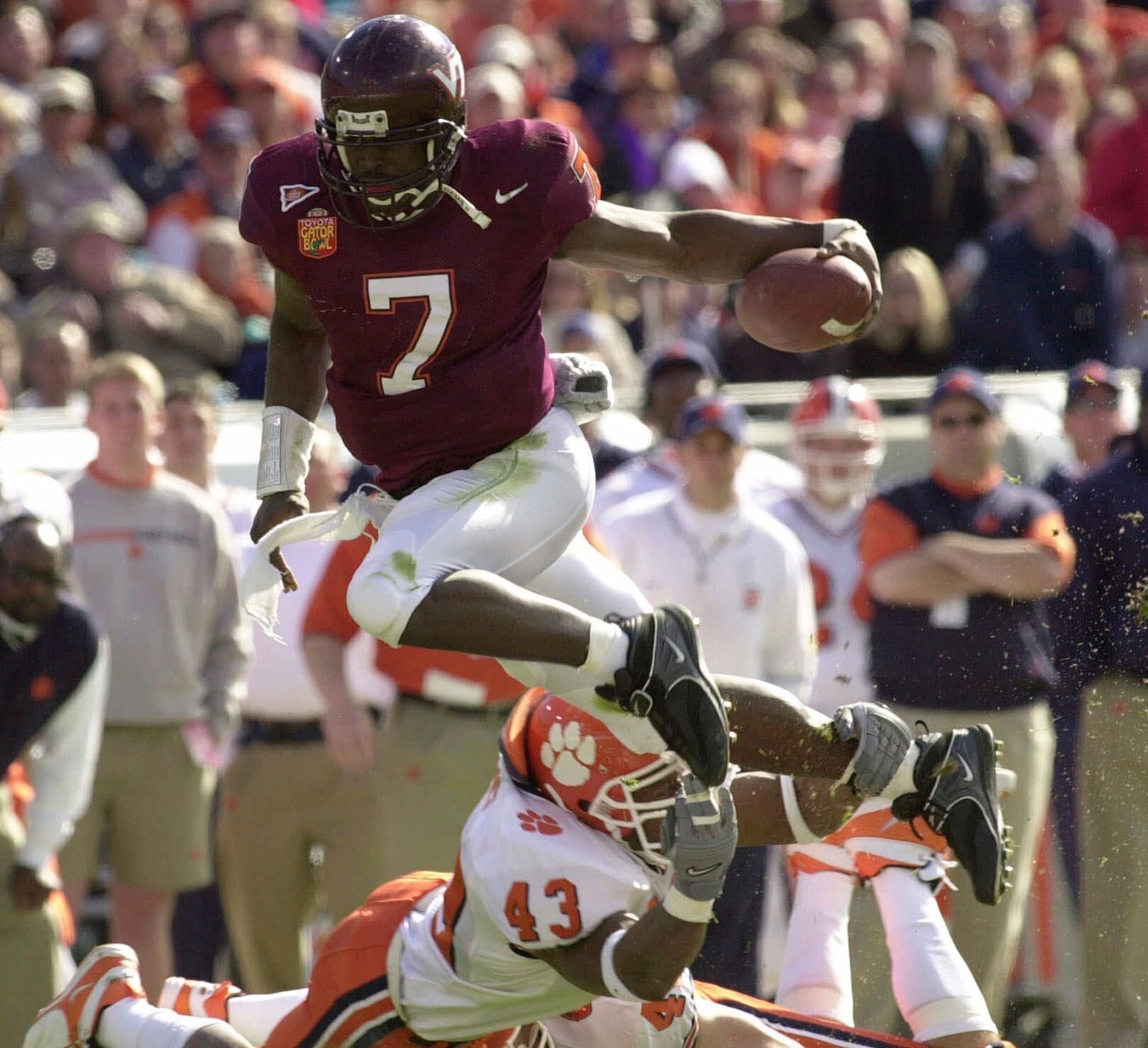 FILE - Virginia Tech quarterback Michael Vick (7) eludes Clemson's Keith Adams for a short gain in the first quarter of the Gator Bowl in Jacksonville, Fla., Monday, Jan. 1, 2001. Michael Vick, (AP Photo/Steve Helber, File)