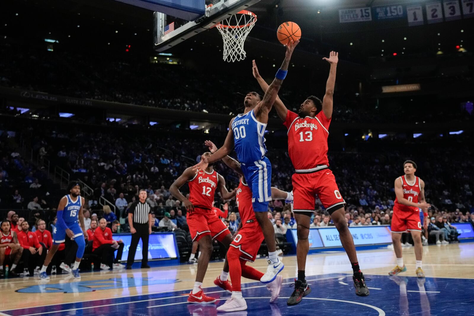 Kentucky's Otega Oweh, center, drives past Ohio State's Sean Stewart (13) during the first half of an NCAA college basketball game in the CBS Sports Classic, Saturday, Dec. 21, 2024, in New York. (AP Photo/Frank Franklin II)