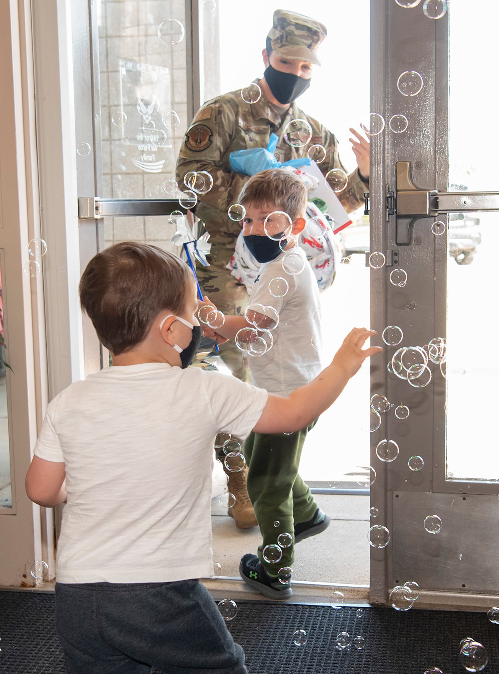 Ryder (foreground) and Ronin McCool chase bubbles as they leave the New Horizons Child Development Center on April 30 with their mother, Master Sgt. Karla McCool, 88th Force Support Squadron first sergeant. U.S. AIR FORCE PHOTO/R.J. ORIEZ