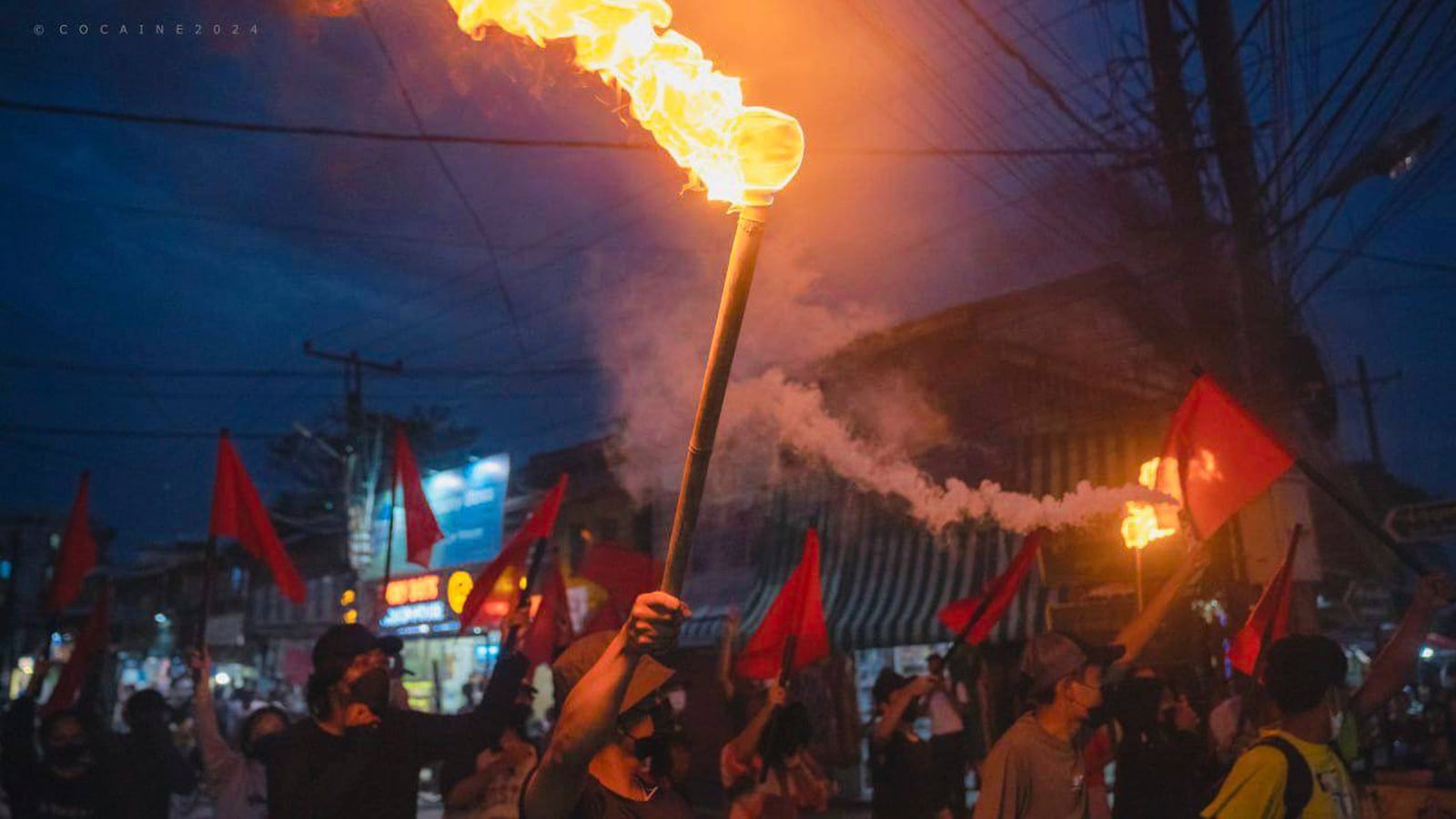 Pro-democracy protesters hold torches and flags during a flash mob rally to protest against Myanmar's military-government in Yangon, Myanmar on Sept.19, 2024. (Anti-Junta Alliance Yangon via AP)