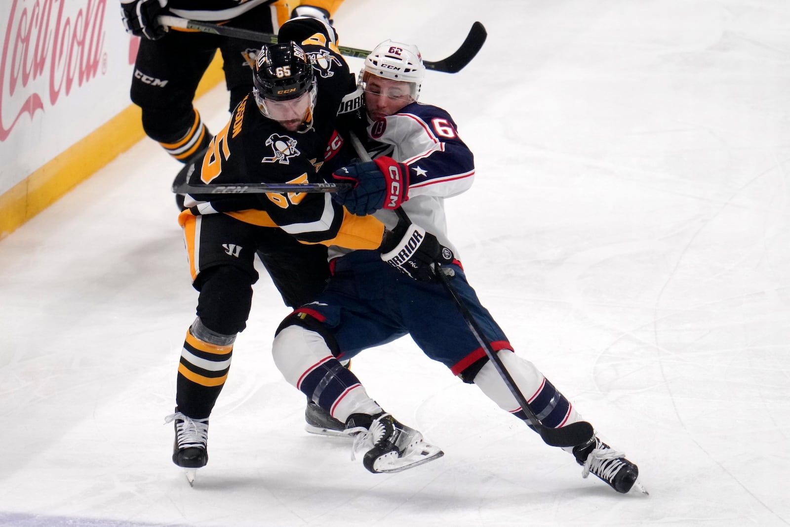 Pittsburgh Penguins' Erik Karlsson (65) checks Columbus Blue Jackets' Kevin Labanc (62) off his skates during the first period of an NHL hockey game in Pittsburgh, Tuesday, Jan. 7, 2025. (AP Photo/Gene J. Puskar)