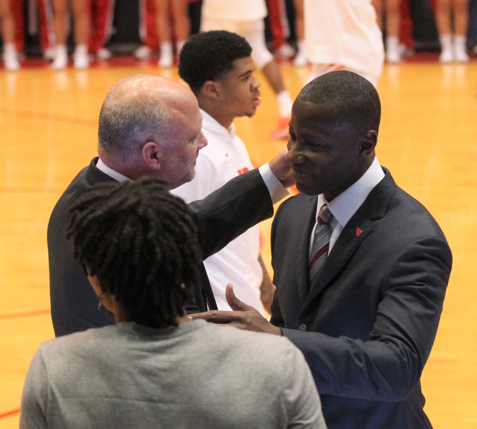 Capital’s Damon Goodwin, left, and Dayton’s Anthony Grant hug before an exhibition game on Friday, Nov. 2, 2018, at UD Arena.