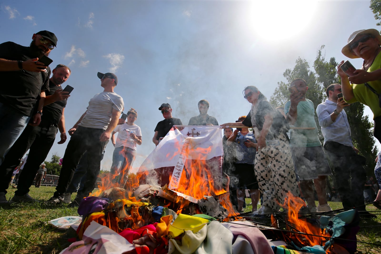 FILE - Opponents of gay rights burn LGBTQ+ flags and symbols as they try to interfere a pride event in Tbilisi, Georgia, on July 8, 2023. (AP Photo/Zurab Tsertsvadze, File)