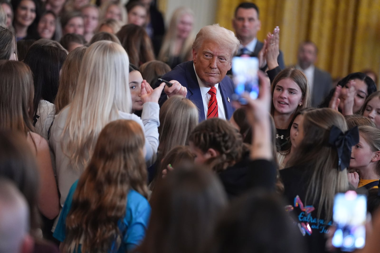 President Donald Trump hands a pen to Riley Gaines after signing an executive order barring transgender female athletes from competing in women's or girls' sporting events, in the East Room of the White House, Wednesday, Feb. 5, 2025, in Washington.(AP Photo/ Evan Vucci)