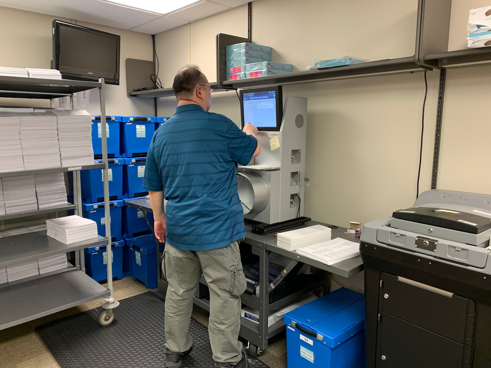 A Montgomery County Board of Elections worker runs paper ballots through a scanner to recount a polling location after the USB card from that location malfunctioned.