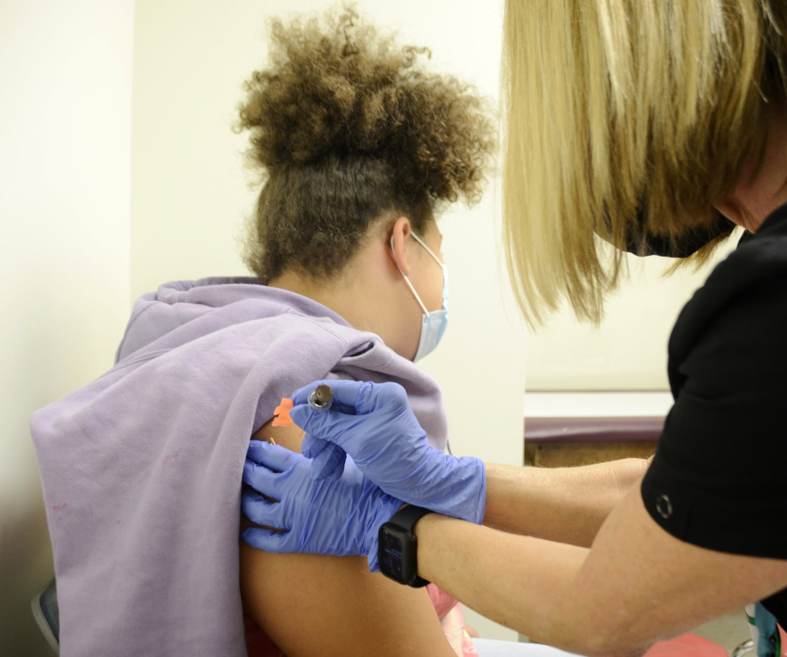 Brooklyn Brundidge, 12, a seventh-grader at Garfield Middle School in Hamilton, receives a vaccine shot on Wednesday, Sept. 14, 2022, from Public Health Nurse Betsy Waldeck at the Butler County General Health District clinic in downtown Hamilton. MICHAEL D. PITMAN/STAFF