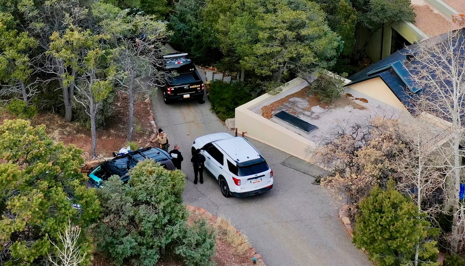 Law enforcement officials talk outside the home of actor Gene Hackman on Thursday, Feb. 27, 2025 in Santa Fe, New Mexico. Hackman, his wife Betsy Arakawa and their wife were found dead in the home a day earlier. (AP Photo/Roberto Rosales)