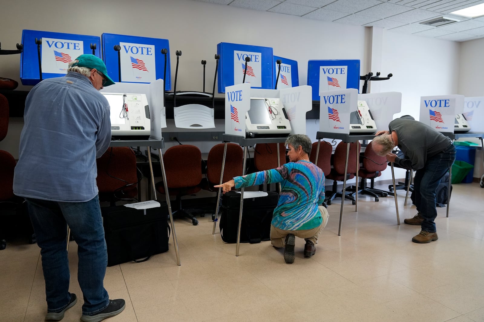 Poll workers set up ballot-marking machines at an early in-person voting site at Asheville-Buncombe Technical Community College, Wednesday, Oct. 16, 2024, in Marshall, N.C. (AP Photo/Stephanie Scarbrough)