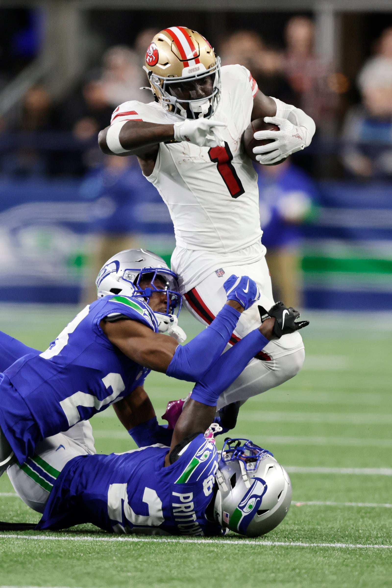 San Francisco 49ers wide receiver Deebo Samuel Sr. (1) is tackled by Seattle Seahawks cornerback Nehemiah Pritchett (28), below, and cornerback Artie Burns (23), left, during the second half of an NFL football game, Thursday, Oct. 10, 2024, in Seattle. (AP Photo/John Froschauer)