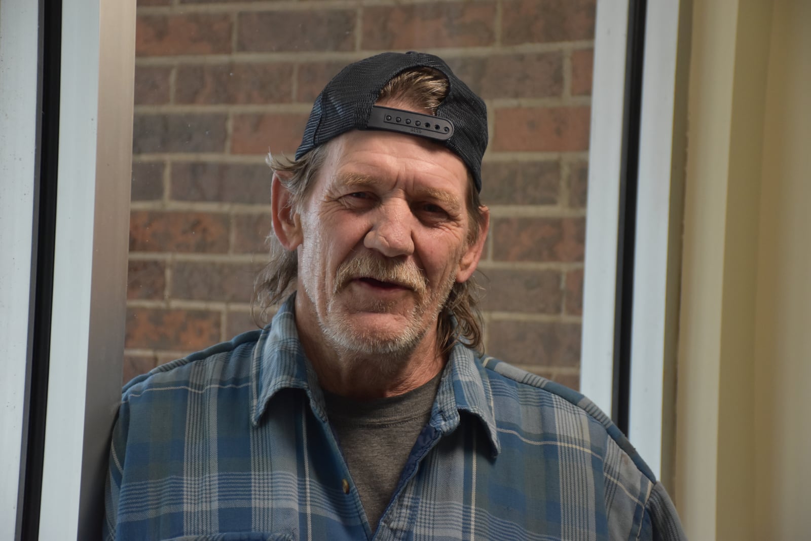 William Lingle says he would like to see new guardrail installed in front of his apartment building at 2308 Wayne Ave. in Dayton to try to prevent future vehicle strikes. CORNELIUS FROLIK / STAFF