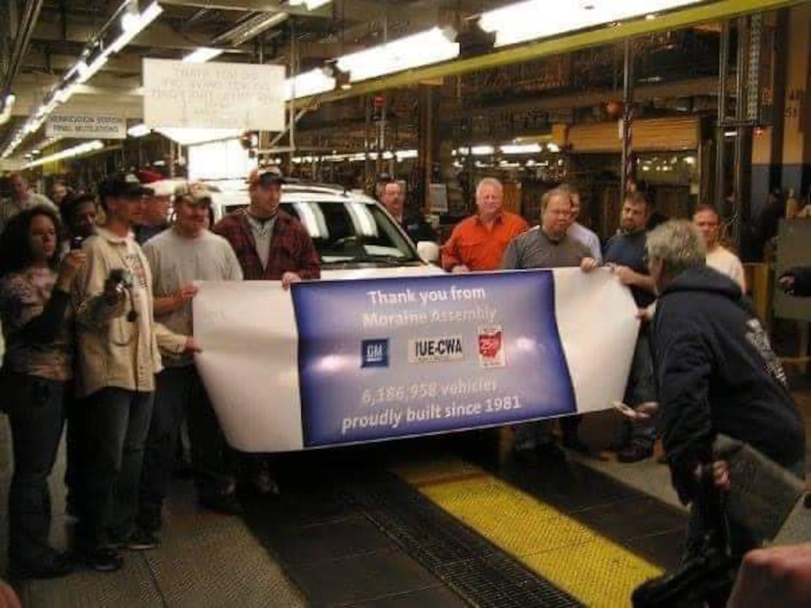 A group of workers at the General Motors SUV assembly plant gather around the last vehicle assmebled at the plant on Dec. 23, 2008, the day the plant closed. This photo was provided by former GM-Moraine worker Kate Geiger.