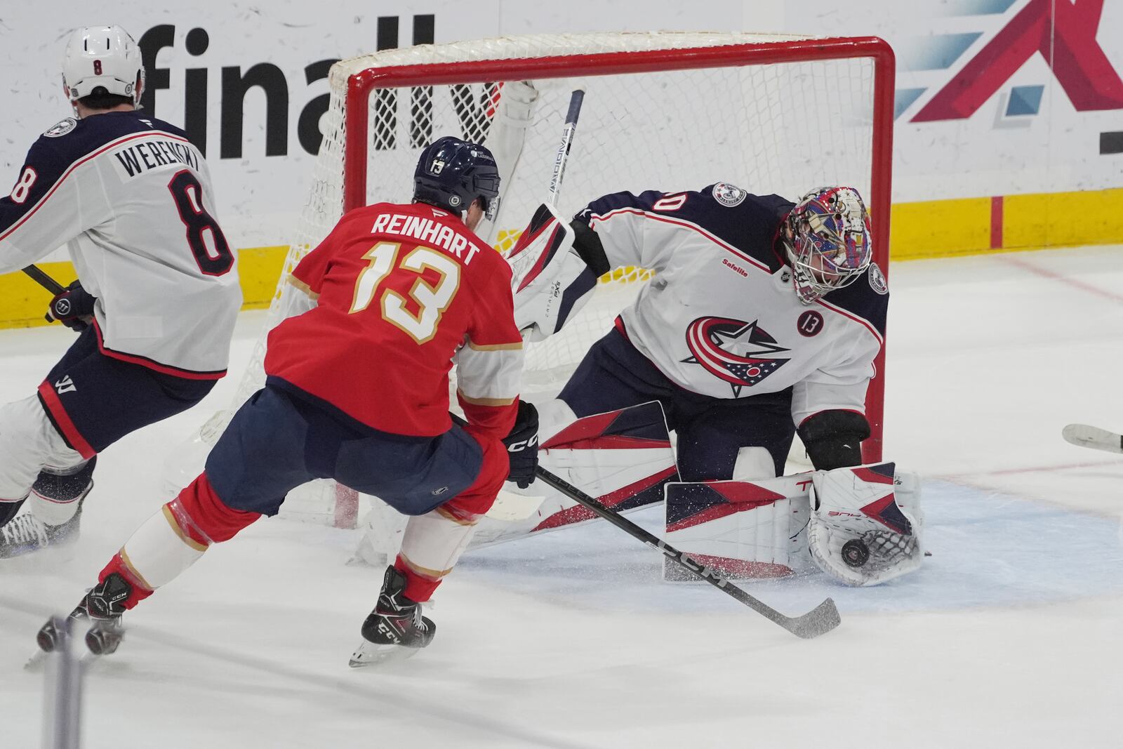 Columbus Blue Jackets goaltender Elvis Merzlikins (90) grabs a shot by Florida Panthers center Sam Reinhart (13) during the first period of an NHL hockey game, Thursday, March 6, 2025, in Sunrise, Fla. (AP Photo/Marta Lavandier)