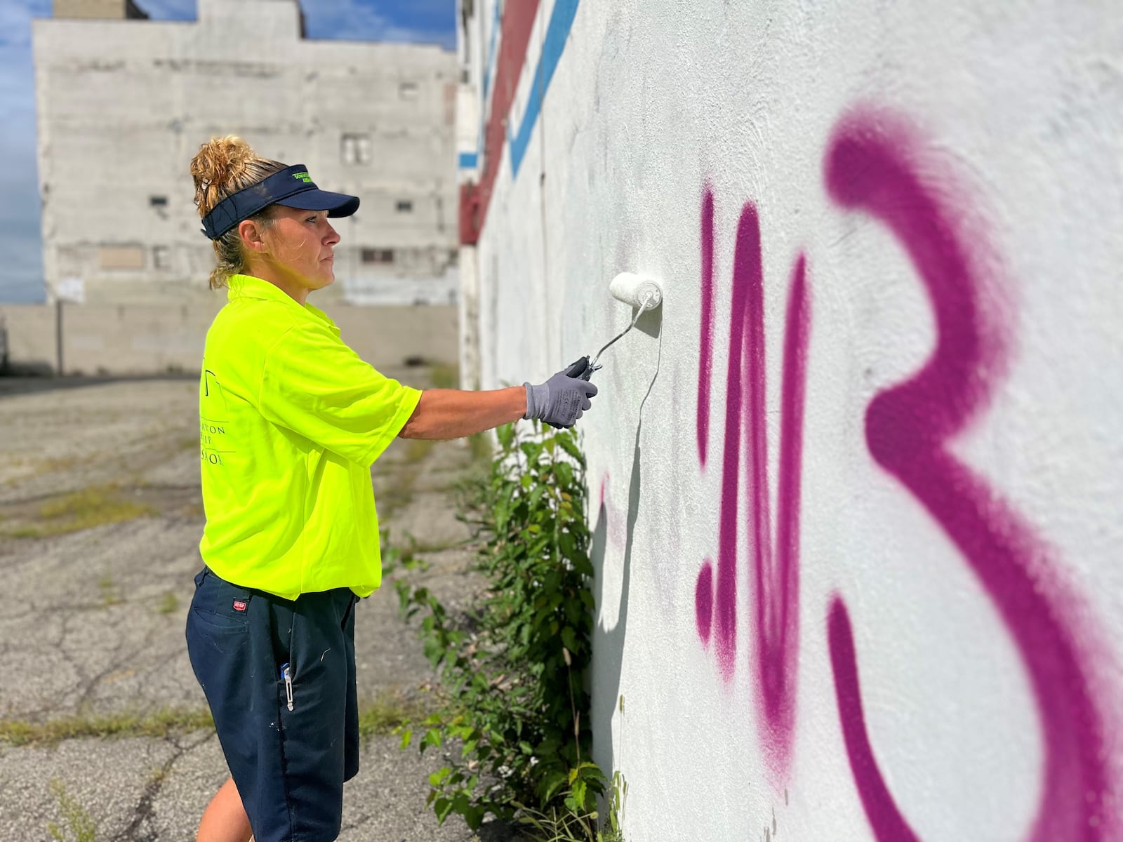 Angel Blanton, special projects ambassador with the Downtown Ambassador program, paints over a graffiti tag on the side of the Fidelity building in downtown Dayton on Friday, Sept. 8, 2023. CORNELIUS FROLIK / STAFF