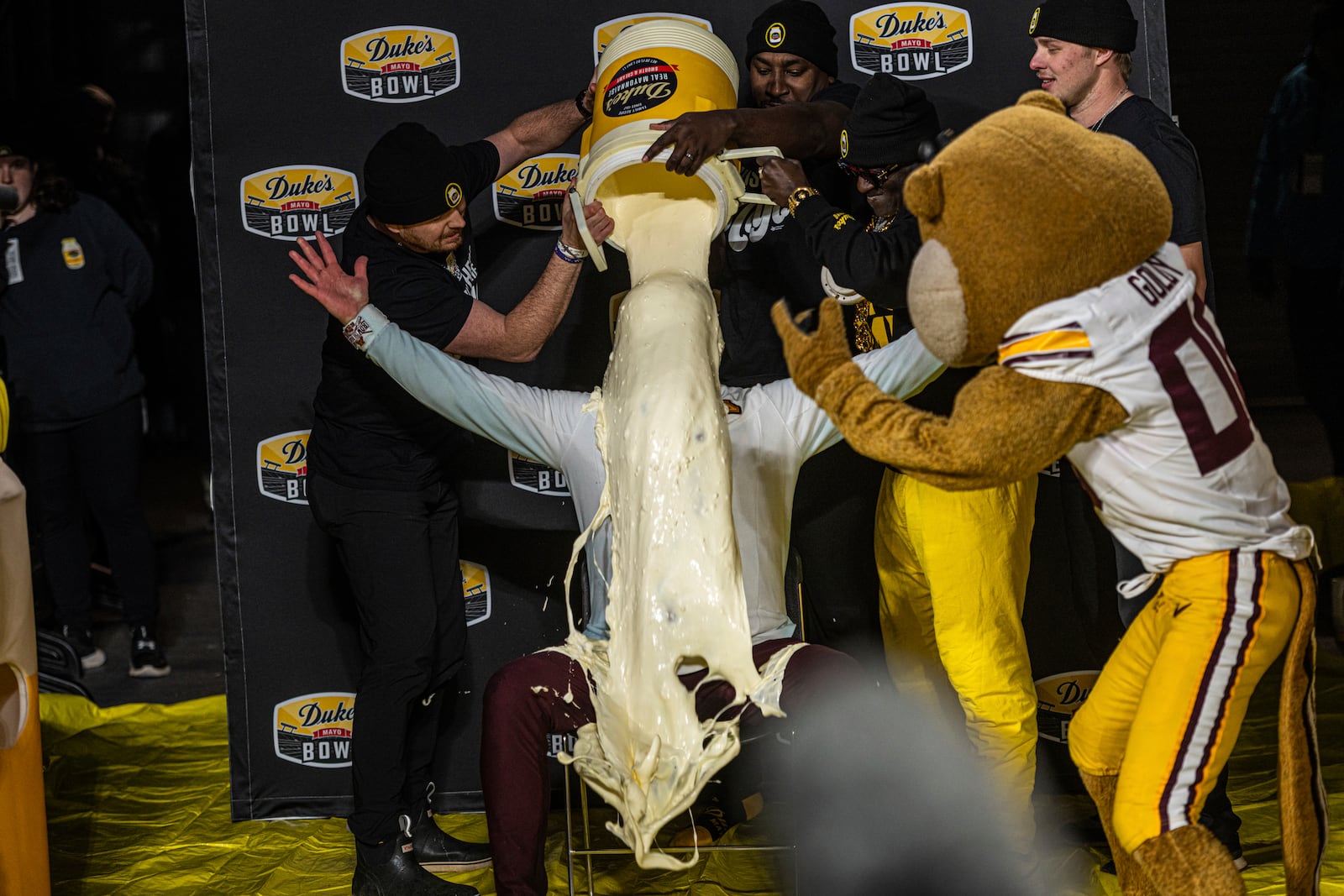 Minnesota head coach P.J. Fleck, center, receives the mayo dump after winning the Duke's Mayo Bowl NCAA college football game against Virginia Tech, Friday, Jan. 3, 2025, in Charlotte, N.C. (AP Photo/Robert Simmons)