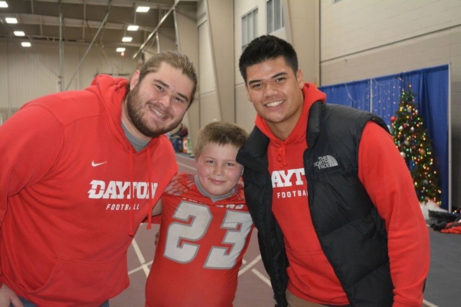 Former Dayton Flyers offensive lineman Ryan Culhane (left) and tight end Matthew Young with Ryan’s pal, Ryder, a Horace Mann student, at Christmas on Campus festivities at the University of Dayton in 2018. CONTRIBUTED