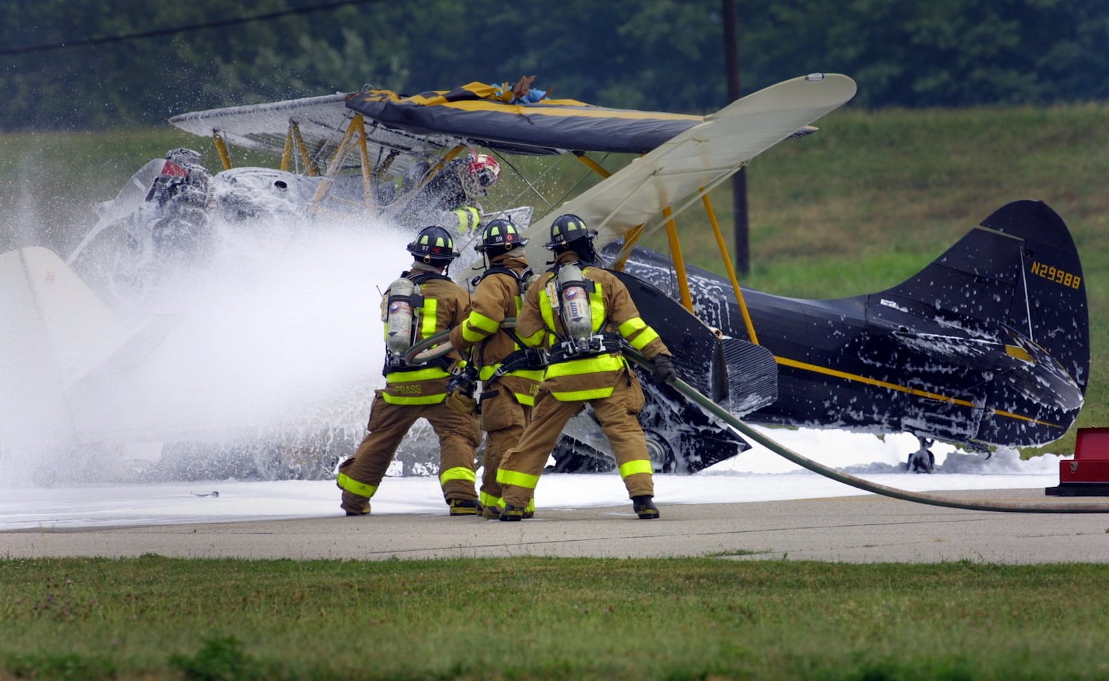 Firefighters work on the scene of a two plane collision on the runway at Moraine Air Park in 2002. White fire retardant foam was sprayed on the planes and the surrounding area. Firefighting foams are under scrutiny because many contain PFAS chemicals. Two sites where PFAS has been used in firefighting foam, Wright-Patterson Air Force Base and the city’s fire training center, sit above the aquifer. JIM WITMER / STAFF