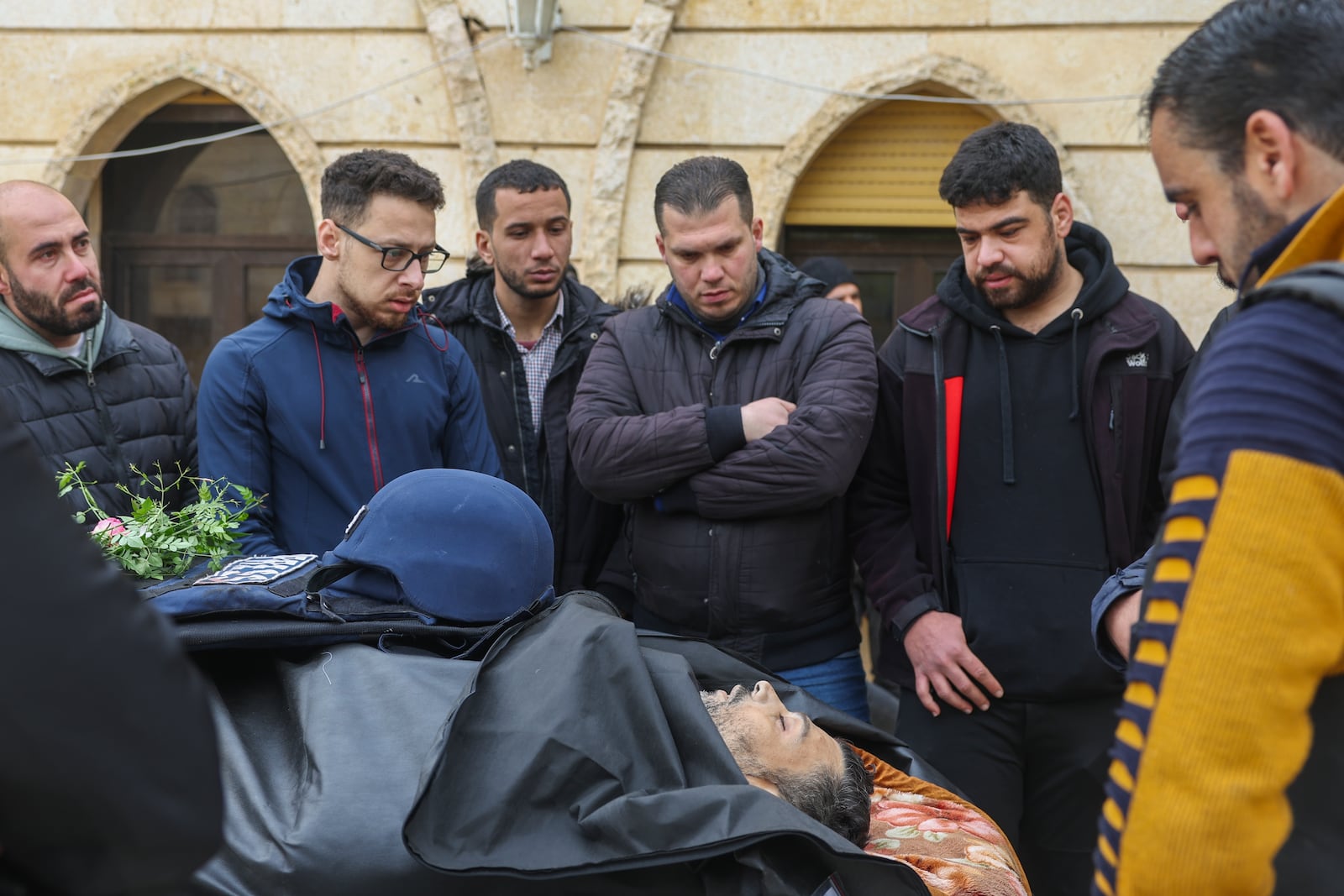 Colleagues and friends mourn over the body of Syrian photographer Anas Alkharboutli, 32, in Idlib, Syria, Wednesday Dec. 4, 2024. Alkharboutli, working for the German news agency DPA was killed in an airstrike near the city of Hama, the agency said Wednesday.(AP Photo/Ghaith Alsayed)