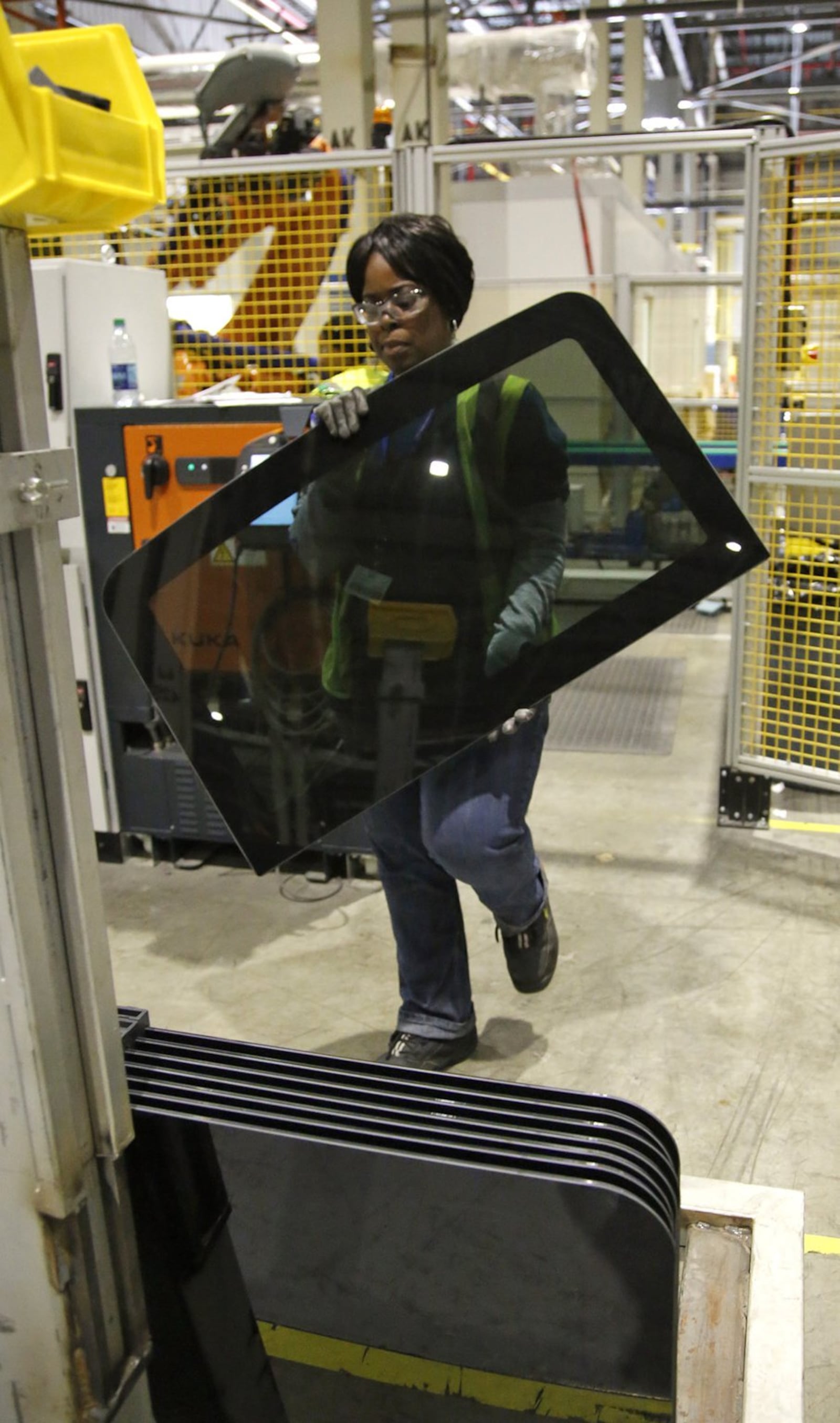 Production glass for automobiles is loaded onto racks before after being laminated at Fuyao Glass America. TY GREENLEES / STAFF