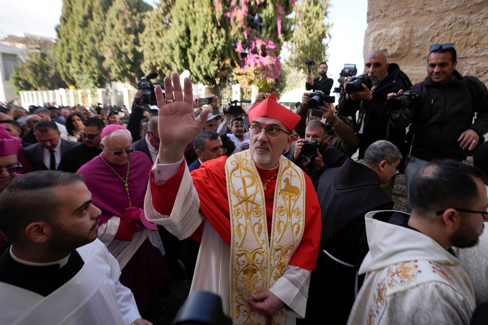 Latin Patriarch Pierbattista Pizzaballa, the top Catholic clergyman in the Holy Land, center, waves as he arrives at the Church of the Nativity, traditionally believed to be the birthplace of Jesus, on Christmas Eve in the West Bank city of Bethlehem, Tuesday, Dec. 24, 2024. (AP Photo/Matias Delacroix)