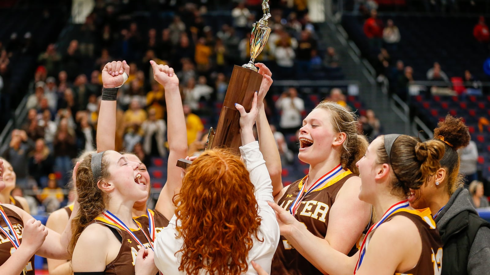 Alter's Maddie Moody (middle right) hoists the trophy with her teammates after the Knights won the Division II girls basketball state championship game at UD Arena on Saturday, March 12, 2022. Michael Cooper/CONTRIBUTED