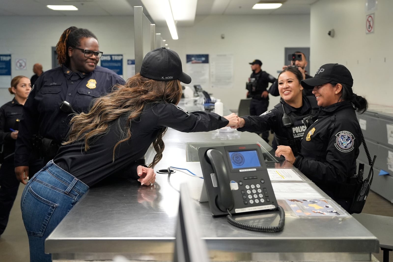 Homeland Security Secretary Kristi Noem, second left, greets officers during a tour of the San Ysidro Port of Entry, Sunday, March 16, 2025, in San Diego. (AP Photo/Alex Brandon)