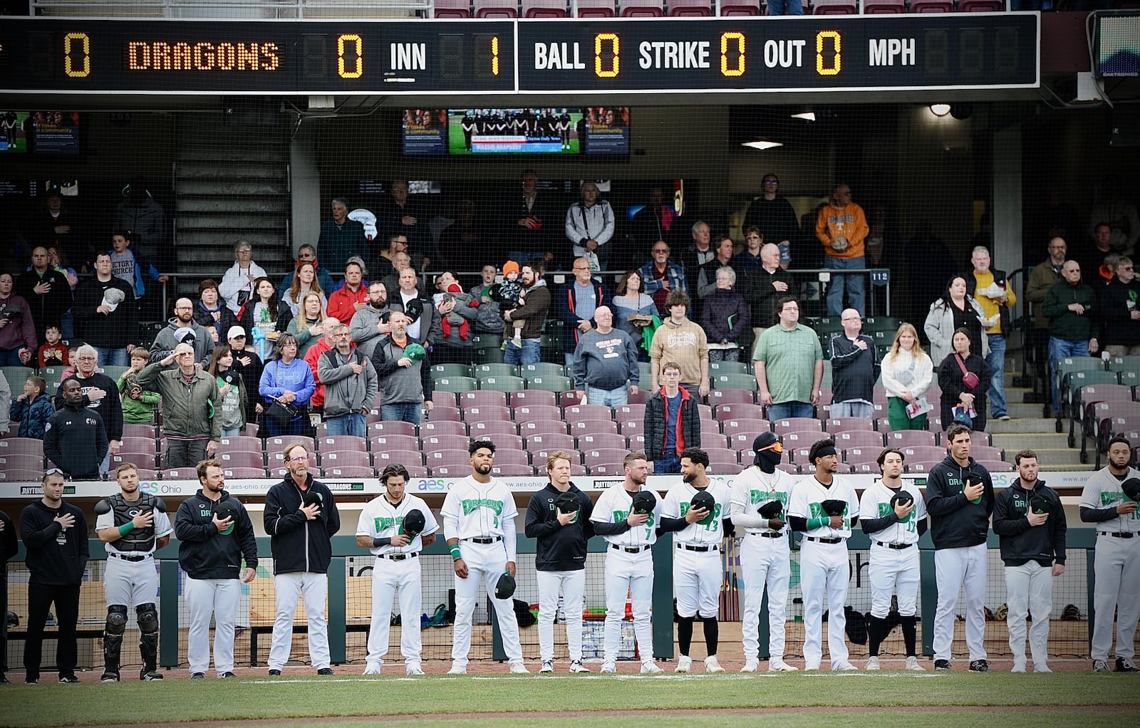 Players and fans stand for the national anthem at an April 2022 Dayton Dragons game at Day Air Ballpark. MARSHALL GORBY \STAFF