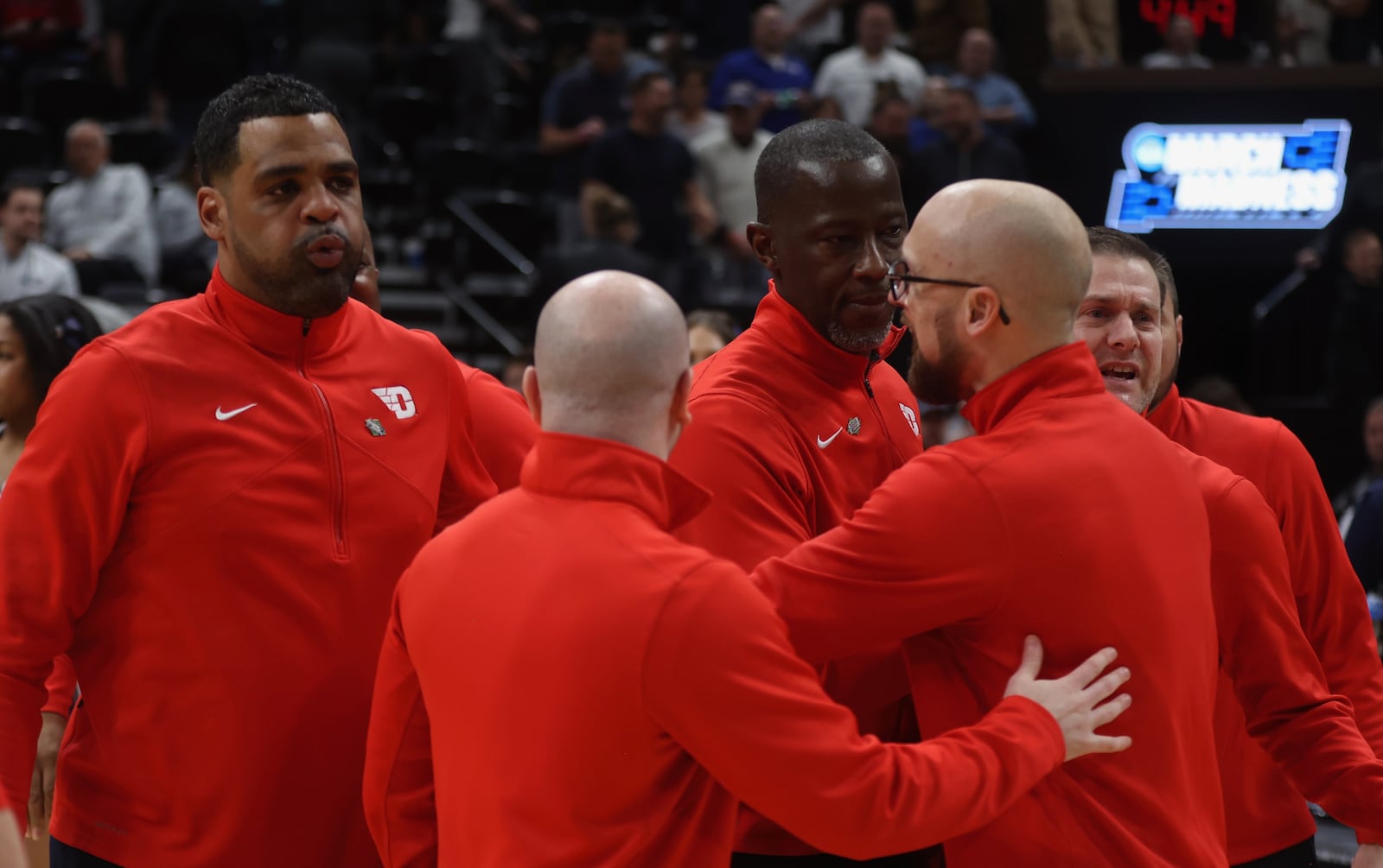 Dayton coaches hug Anthony Grant after a victory against Nevada in the first round of the NCAA tournament on Thursday, March 21, 2024, at the Delta Center in Salt Lake City, Utah. David Jablonski/Staff