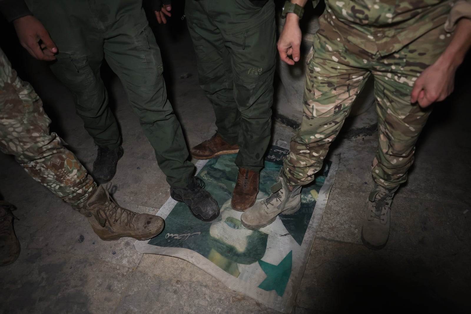 Opposition fighters step on a picture of Syrian President Bashar Assad in Aleppo, Syria, late Friday, Nov. 29, 2024. (AP Photo/Ghaith Alsayed)