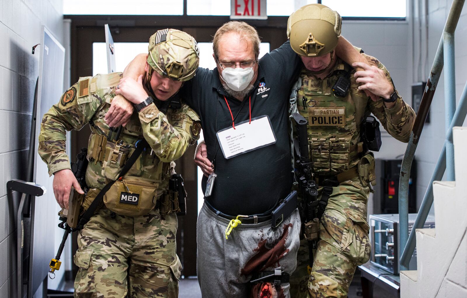 Two Defenders from the 88th Security Forces Squadron assist a wounded “victim” as they safely exit the building during an active-shooter exercise Aug. 10 at Wright-Patterson Air Force Base. U.S. AIR FORCE/JAIMA FOGG